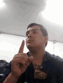 a man with a name tag that says ' alonso ' on it holds his finger up