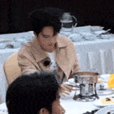 a man is sitting at a table with a pot of food