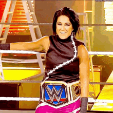 a woman in a wrestling ring with a wwe belt on her waist