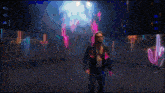 a man in a black jacket stands in front of a neon sign that says wcw on it