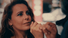 a woman is holding a man 's hand and looking at him