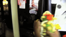 a person holds a stuffed animal in front of a refrigerator door