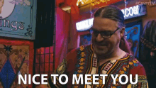 a man wearing glasses and a red shirt says nice to meet you