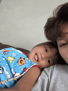 a baby laying on a man 's chest wearing a snoopy outfit