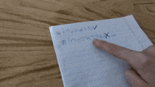 a person 's finger is pointing at a piece of paper that says ' x '