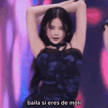 a woman in a blue dress is dancing on a stage with the words baila si eres de moli below her .
