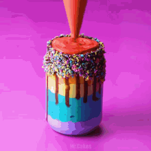 a rainbow colored milkshake is being poured into a mason jar with sprinkles