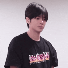 the boy is wearing a black t-shirt with flames on it .