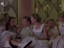 a group of people sitting around a man holding a bottle