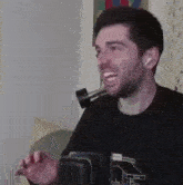 a man with a beard is standing in front of a microphone and making a funny face .