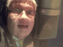 a close up of a person 's face in front of a microphone with the letter r on it