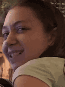 a woman is smiling in front of a sign that says the clans