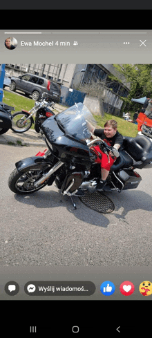 a young boy is sitting on a black motorcycle with the name ewa mochel in the upper right corner