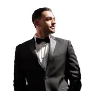 a man in a tuxedo and bow tie looks up