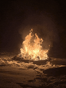 a large fire is burning in the dark with a lot of flames