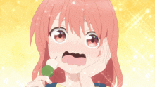 a girl with pink hair is holding a green ball in her mouth