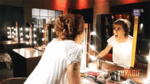 a woman is looking at herself in a mirror with the word voyager on the bottom right