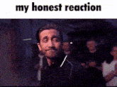 a man is smiling in front of a crowd with the words `` my honest reaction '' .