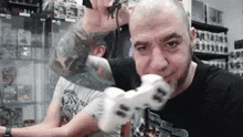 a man with a tattoo on his arm is holding a spider in his mouth while playing a video game .