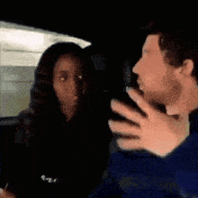 a man and a woman are sitting in the back seat of a car