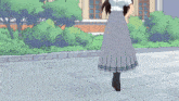 a girl in a pleated skirt is standing on a sidewalk