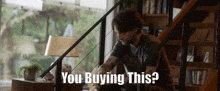 a man is sitting on a set of stairs with the words you buying this