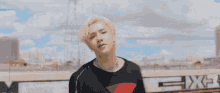 a man with blonde hair is wearing a black sweater