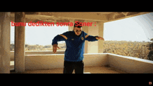 a man in a blue jacket is dancing on a balcony with the words " bunu dedikten sonra soner " written above him
