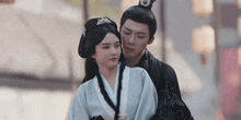 a man and a woman are standing next to each other .