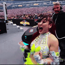 a woman screams in front of a sign that says wrestlemania on it