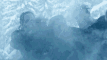 a group of people are surrounded by smoke and one of them is wearing a shirt that says ' salomon '