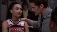 a cheerleader wearing a wmhs uniform is being comforted by a man