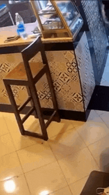 a wooden bar stool is leaning against a counter in a bakery .