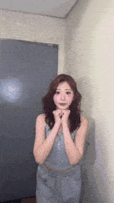 a woman with red hair is standing in front of a door with her hands folded