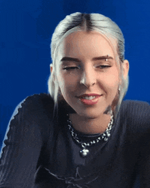 a woman with a nose ring is wearing a black shirt and a silver necklace