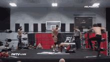 wrestlers in a wrestling ring with the words iwtv live on the bottom