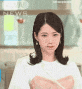 a woman is sitting in front of a screen that says news