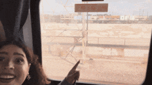 a woman is pointing at a sign that says " do not remove " on it
