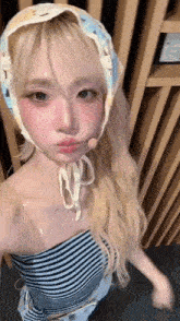 a woman with blonde hair is wearing a striped top and a headband .