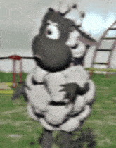 a cartoon sheep is standing in the grass and looking at the camera .
