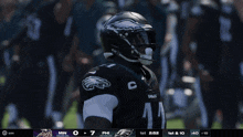 a philadelphia eagles player is holding a football in front of a crowd