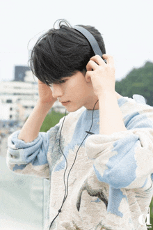 a man wearing headphones and a sweater with the letter d on the bottom