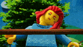 a lego girl with red hair and a blue sweater