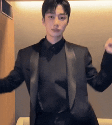 a man in a black suit and black shirt is dancing .