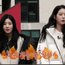 two girls are standing next to each other and one of them is wearing a jacket that says new york on it