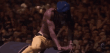 a man without a shirt is kneeling down on a speaker