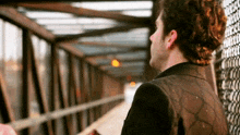 a man is standing on a bridge looking out the window