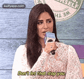 a woman is holding a microphone and talking into it .