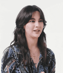 a woman wearing a blue shirt with a cross necklace
