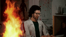 a man in a lab coat is typing on a computer in front of a poster that says vascular system